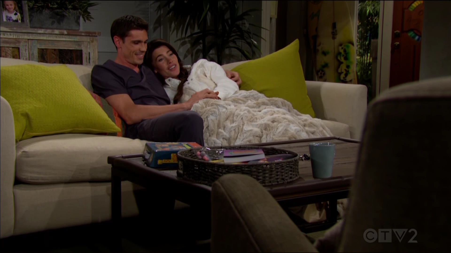 steffy snuggles finn on her sofa with a blanket in the hot summer weather