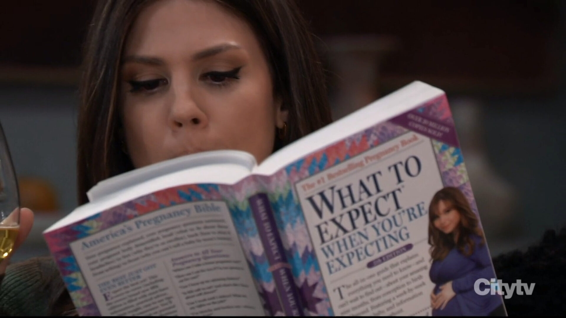 Kristina reads pregnancy books.